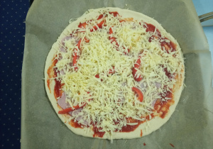 okrągła pizza posypana serem